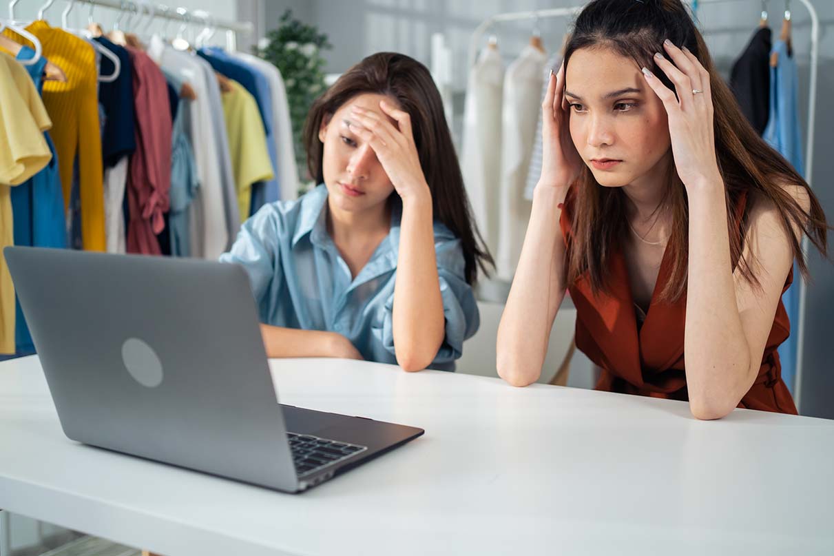 Duas mulheres empreendedoras frustradas com os resultados de vendas online.